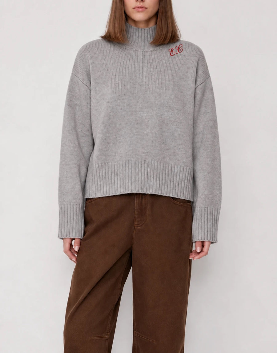Turtleneck gris con iniciales E.C. bordadas en rojo