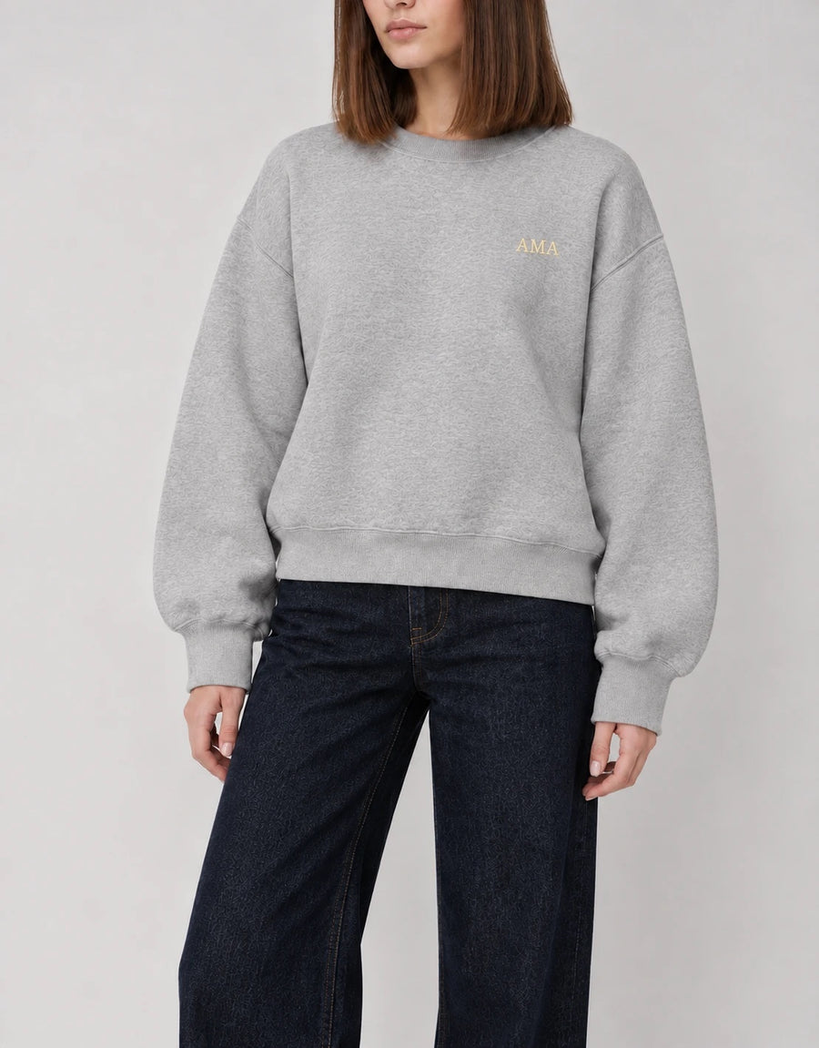 The Classic Crewneck gris con iniciales AMA en hilo dorado, bordado al lado izquierdo del pecho