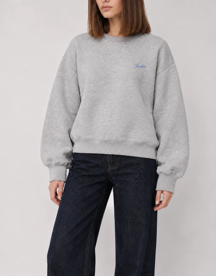 The Classic Crewneck gris con el nombre Juana en hilo azul, bordado al lado izquierdo del pecho