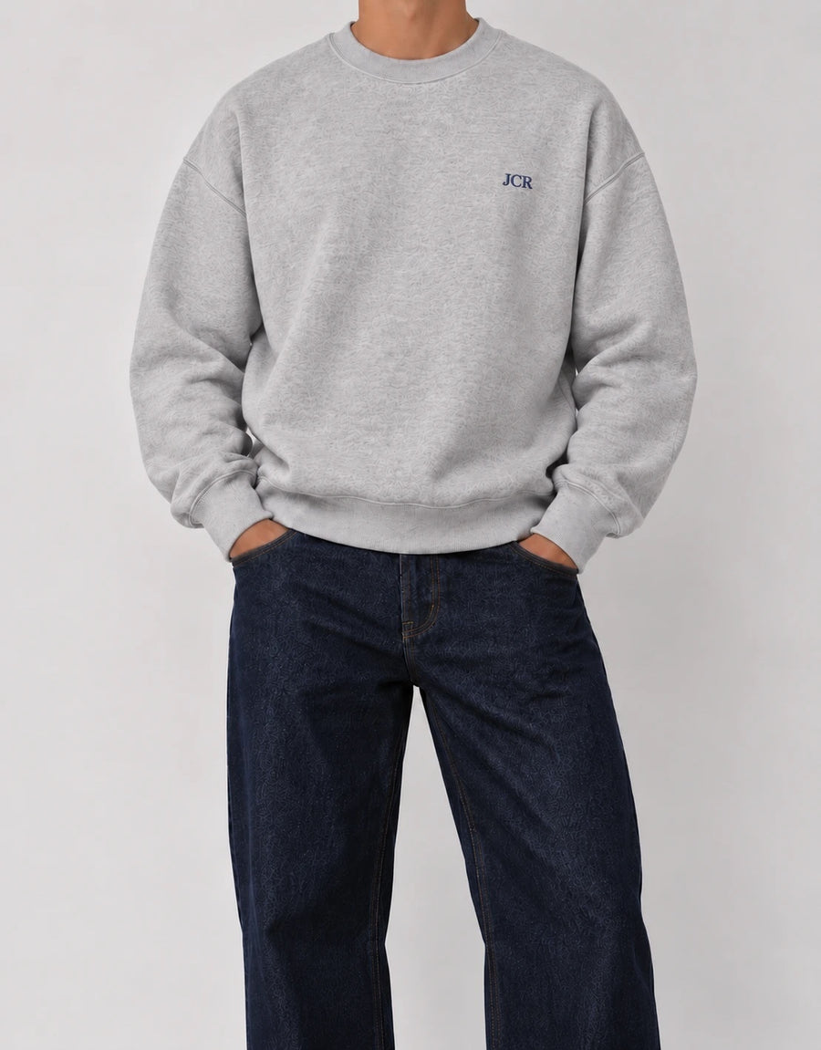 The Classic Crewneck gris con iniciales JCR en hilo navy, bordado al lado izquierdo del pecho